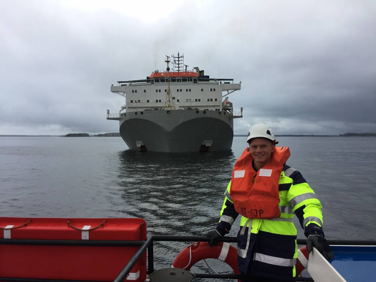 Kevin Lundgaard on deck in front of a heavy-lift vessel